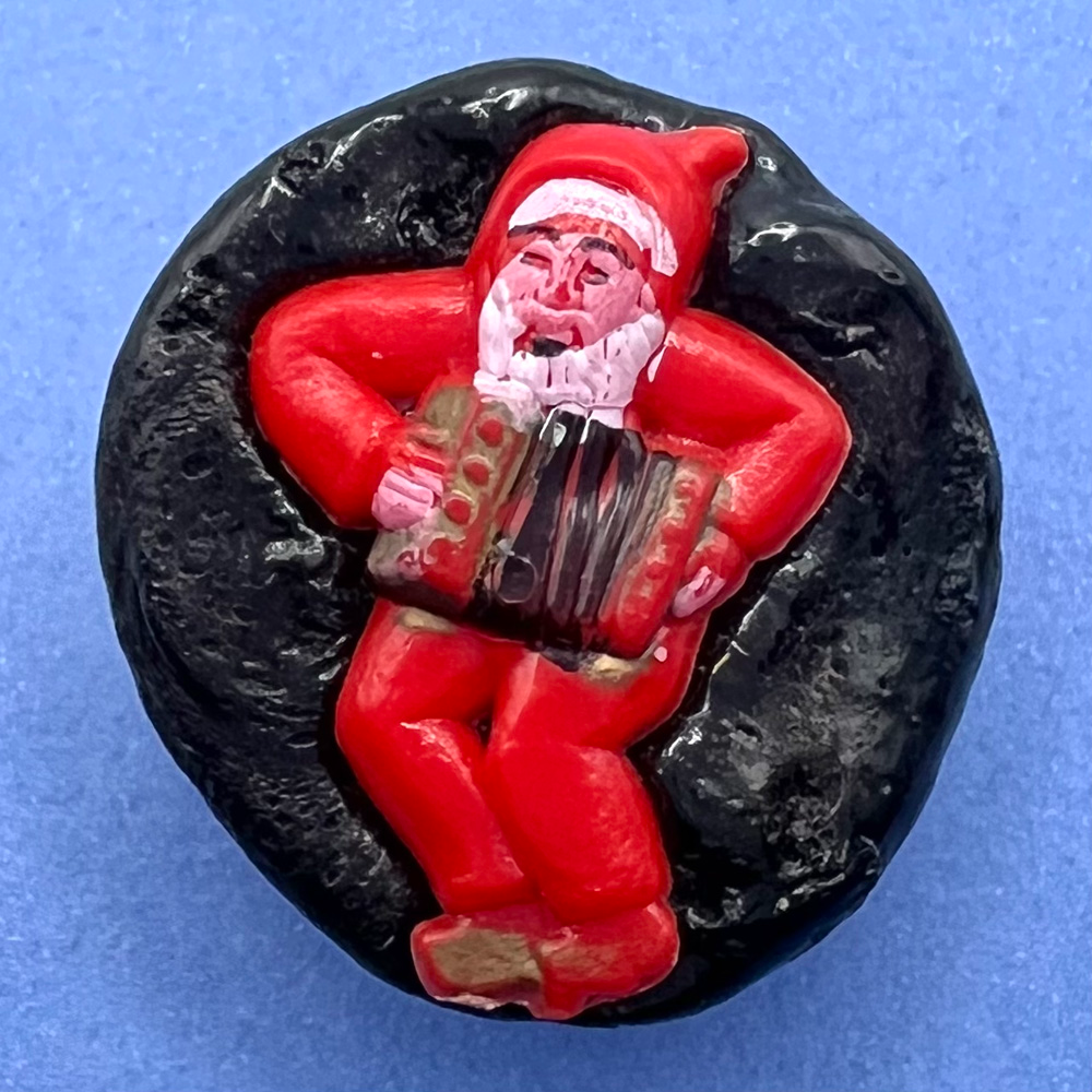 Vintage resin button of Santa Claus playing an accordion.
