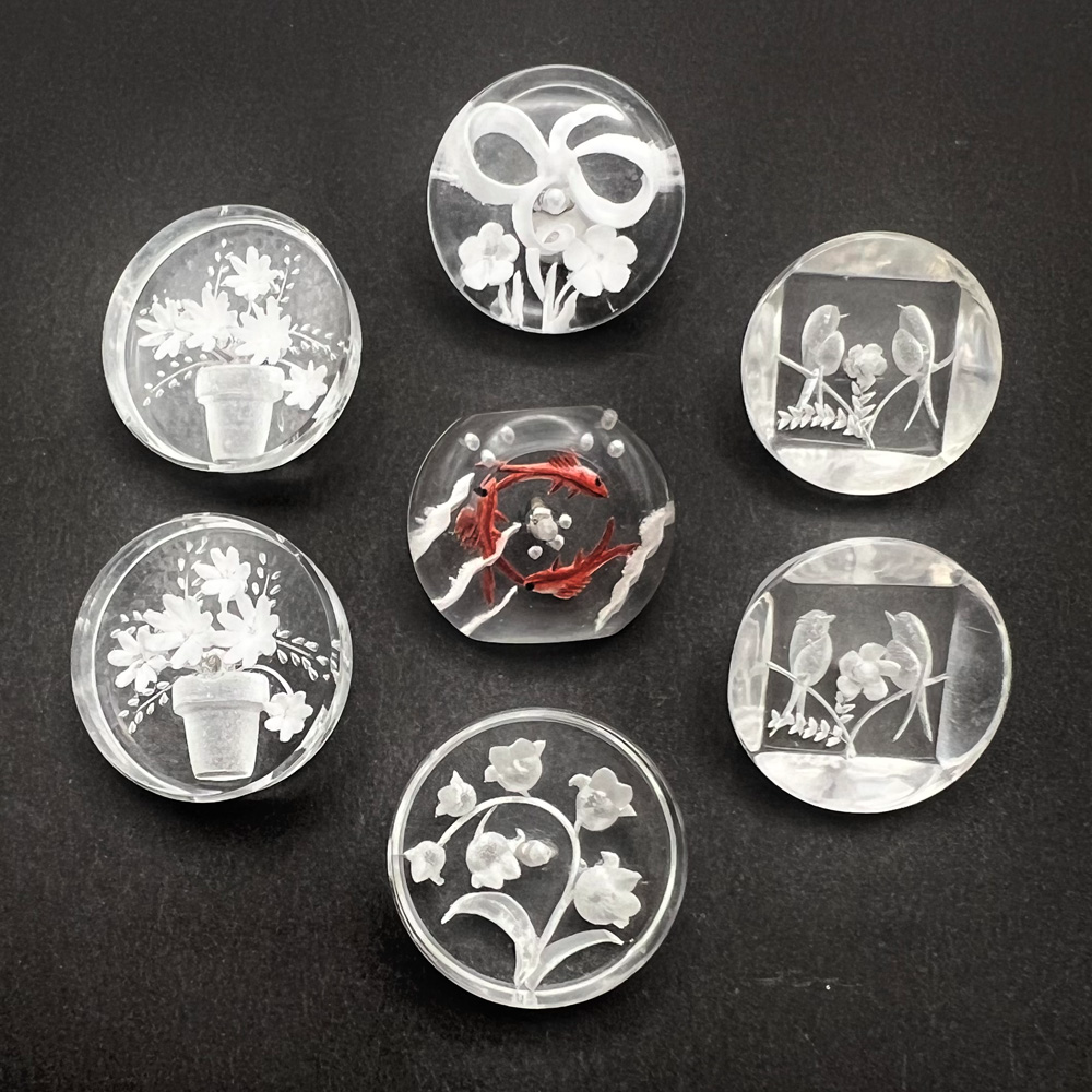 Seven reverse-carved acrylic buttons.