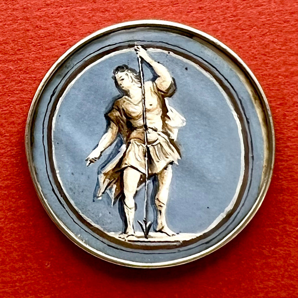 Gauche painting under glass button of a man holding a spear.
