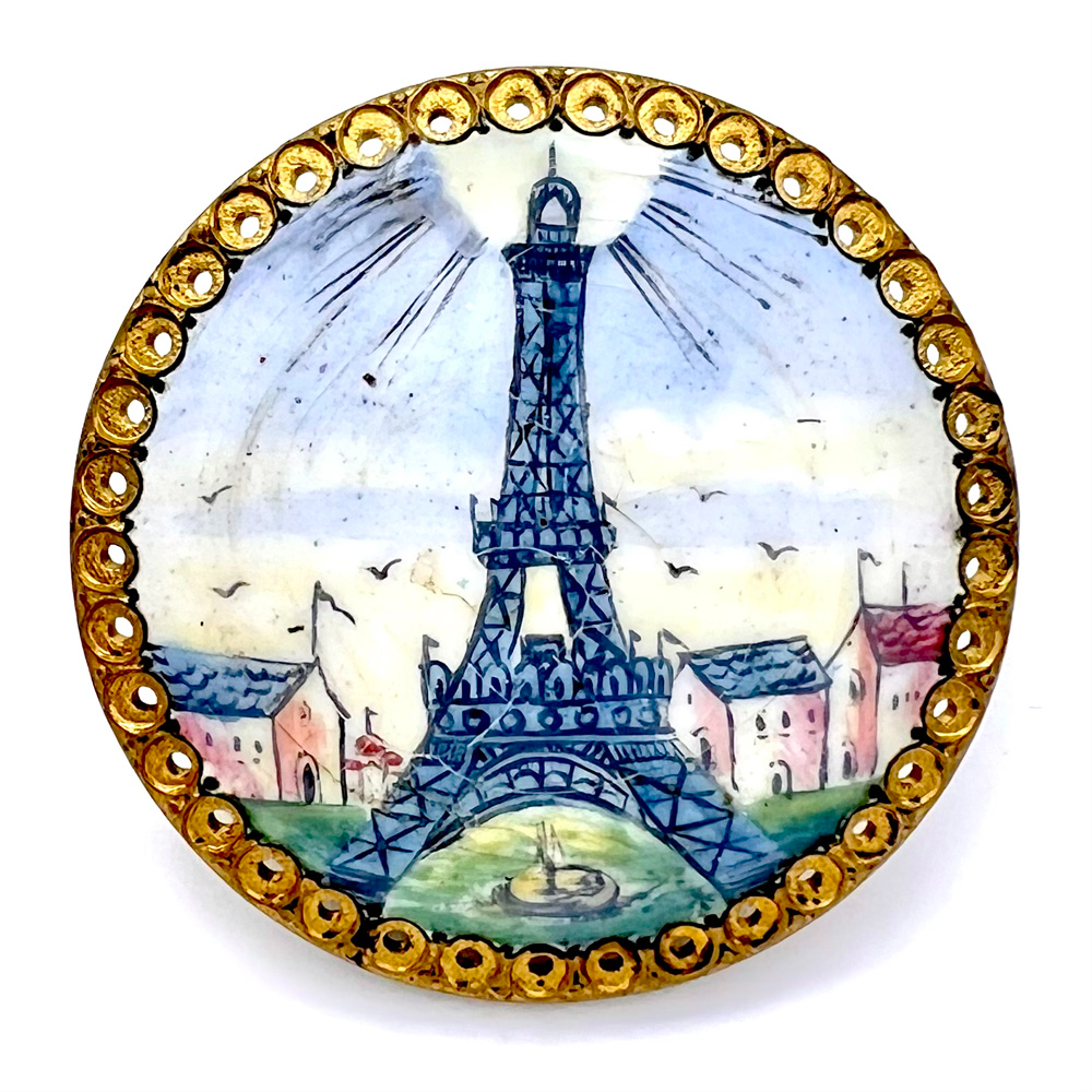 Polychrome painted enamel button of the Eiffel Tower with Paris scene.