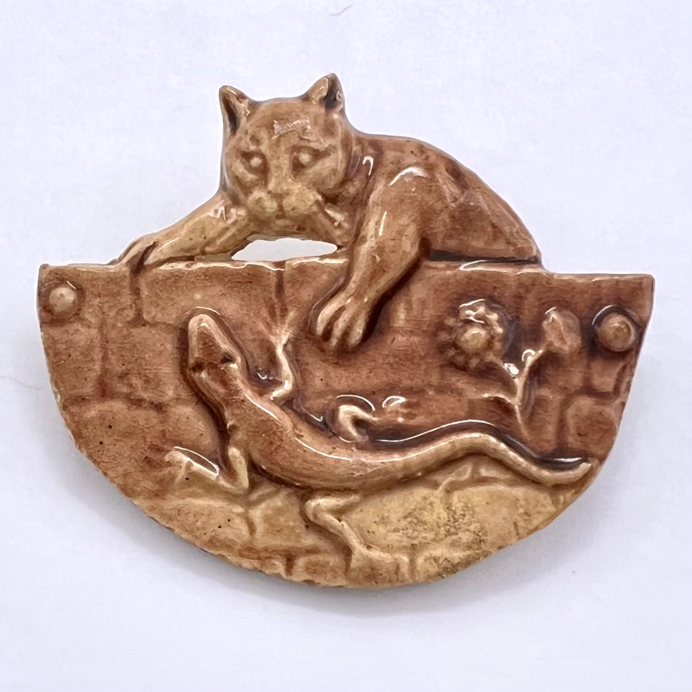 Ceramic button of kitty and lizard.