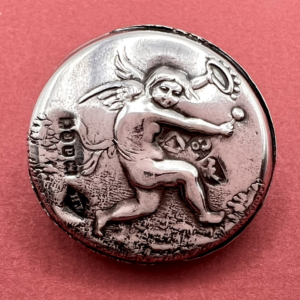 Hallmarked silver button of a Cherub playing musical instruments.