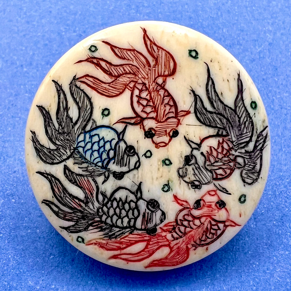 A button of five fish swimming.