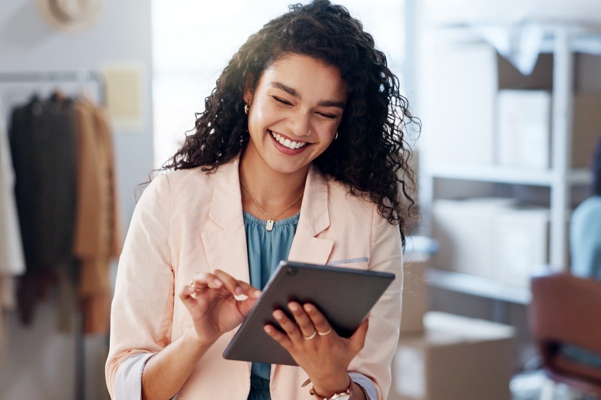 A smiling woman using a tablet