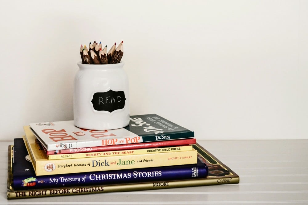 Books in a pile under a pencil holder