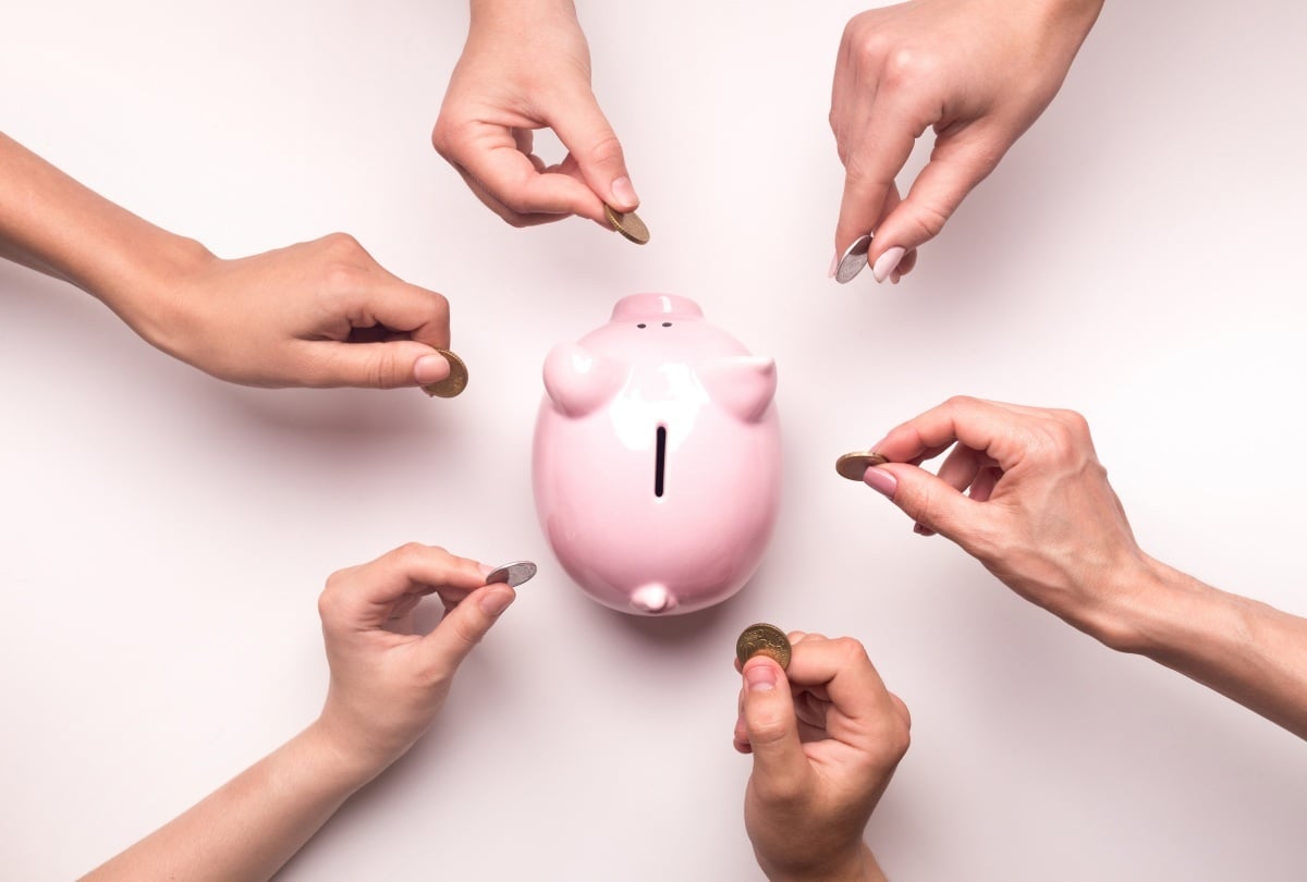 Numerous people putting coins in a piggy bank for Crowdfunding