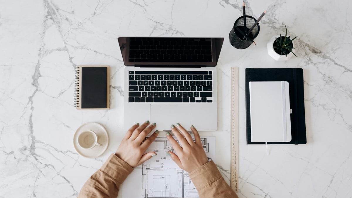 Person about to work on laptop with aesthetically arranged workspace