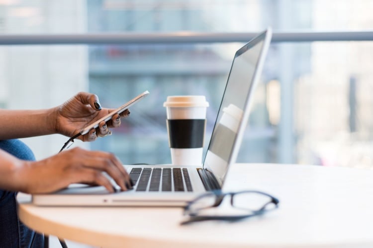 Person using computer and cellphone