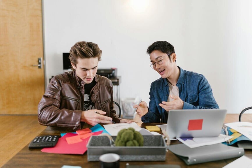 Two men sitting at a desk and working