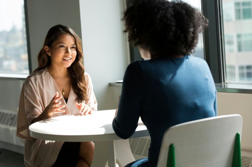 Two women sitting at a table and talking