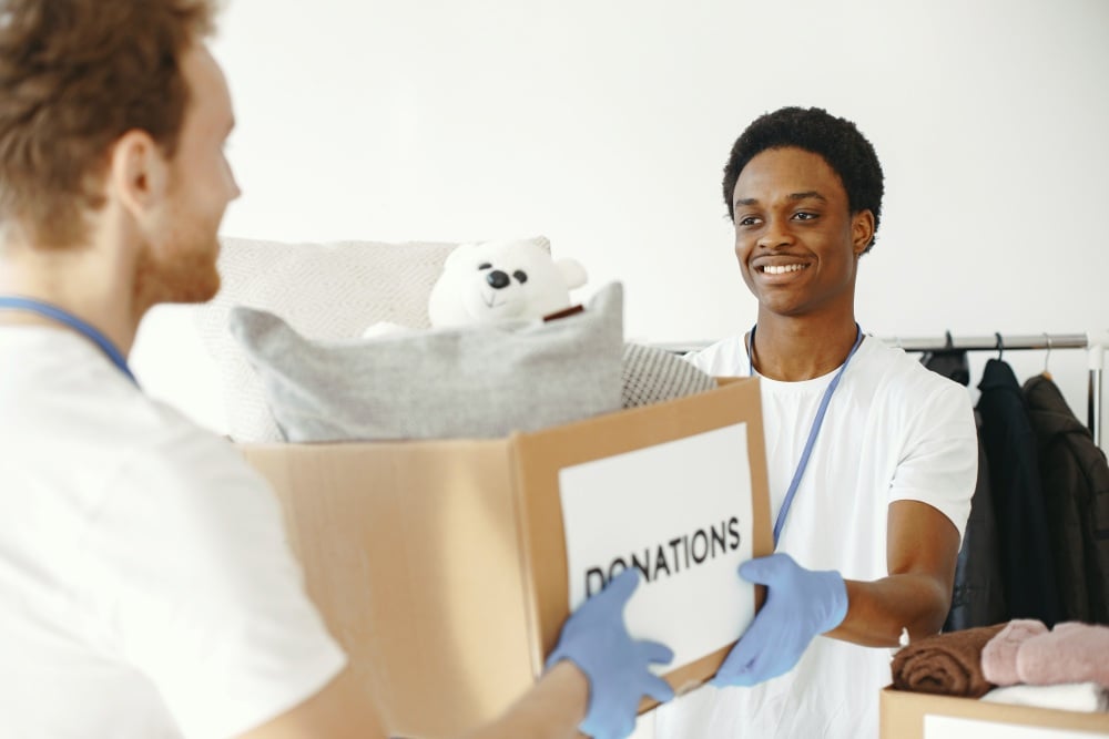 Volunteers carrying a donations box