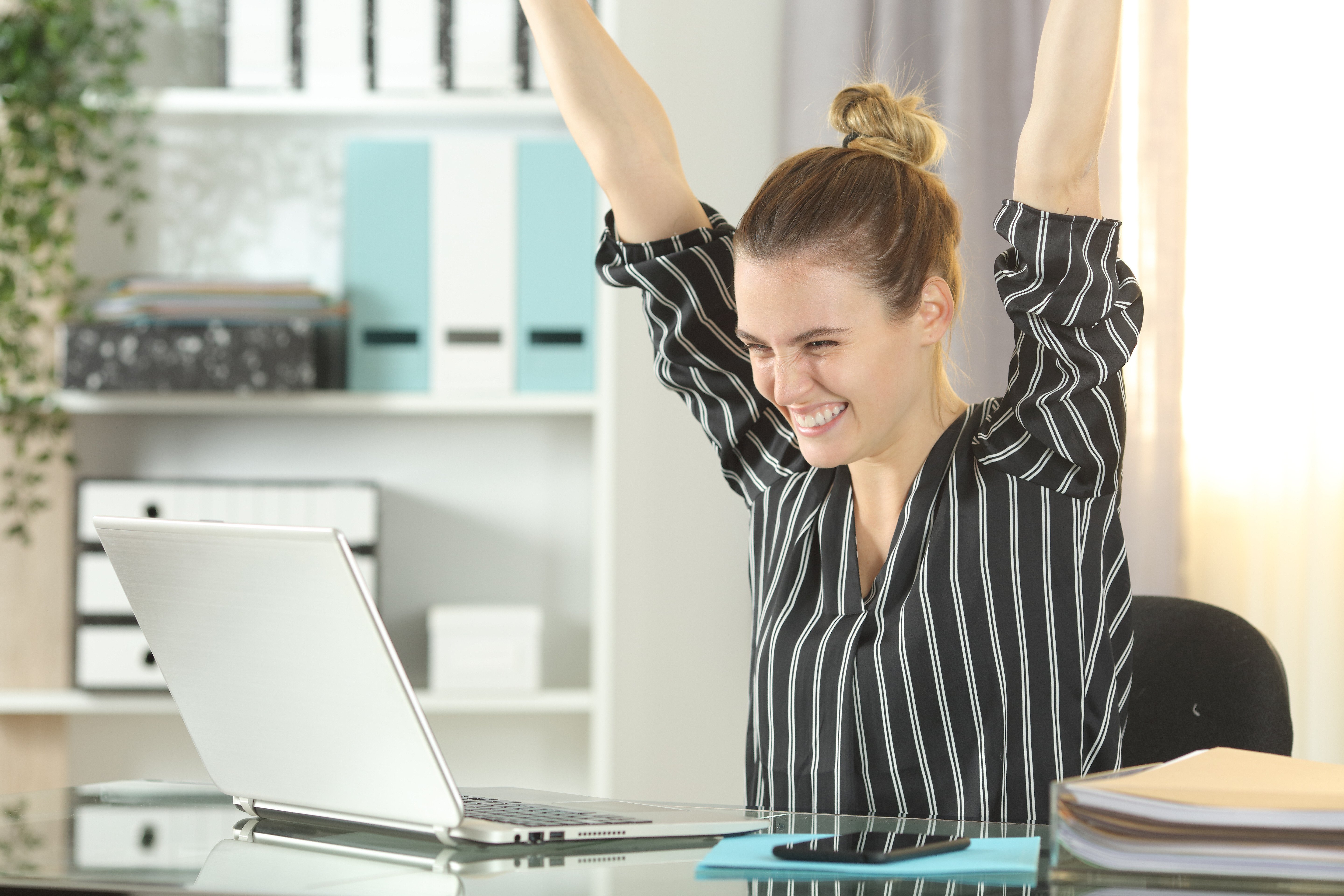 Woman celebrating using auction management software