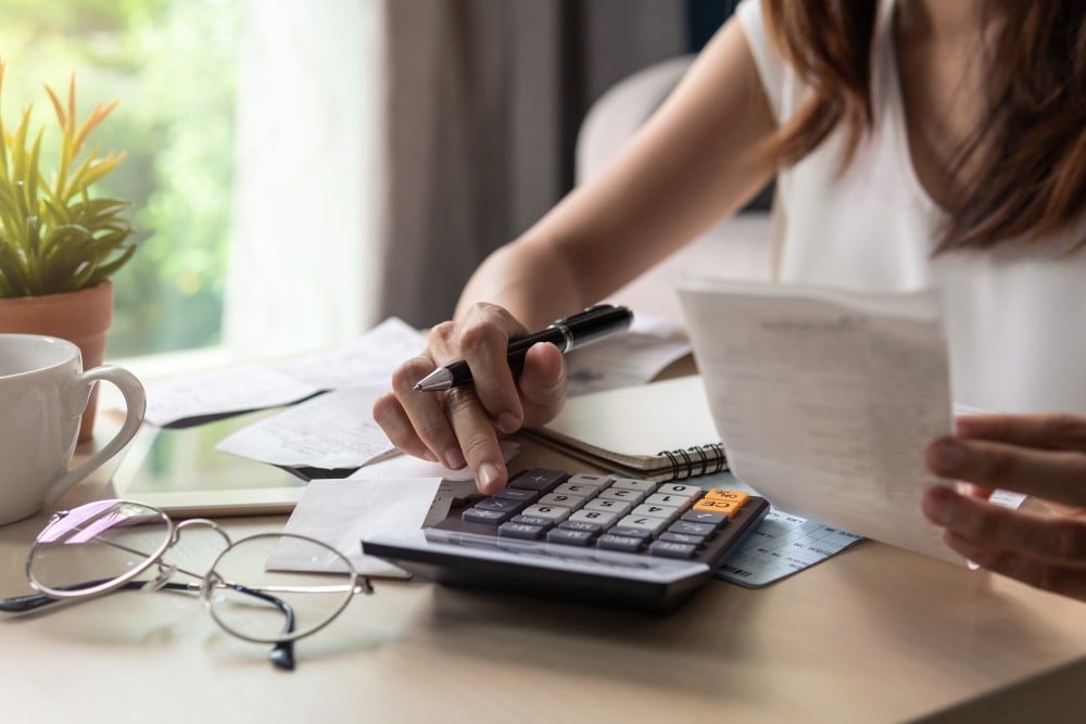 Woman setting a budget with a calculator