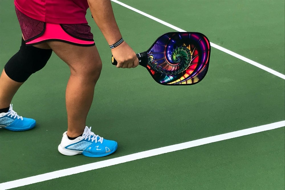 Woman with racquet playing pickleball