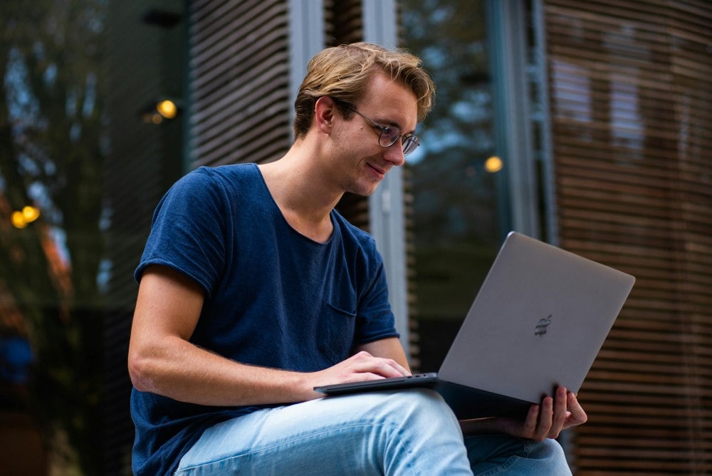 Young man sitting with a laptop