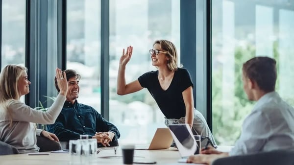 woman high fiving in meeting room