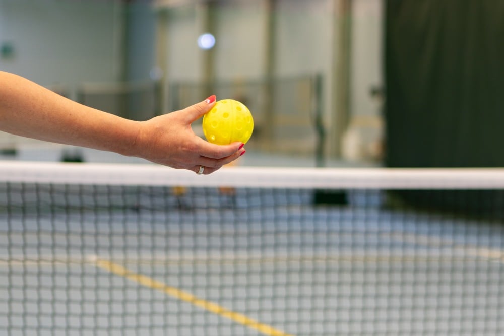 hand holding a pickleball ball