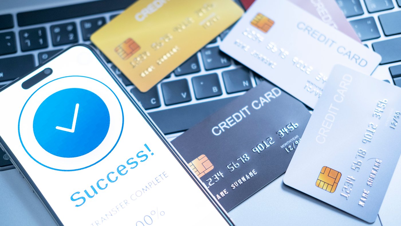 Credit cards placed next to computer and phone