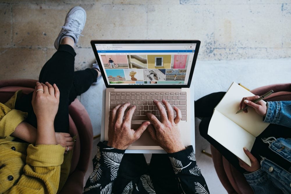 three people sitting in front of laptop