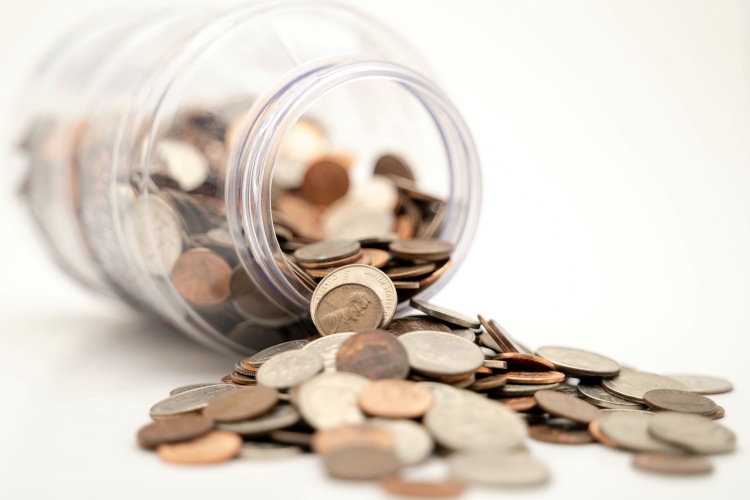 Money jar spilling coins