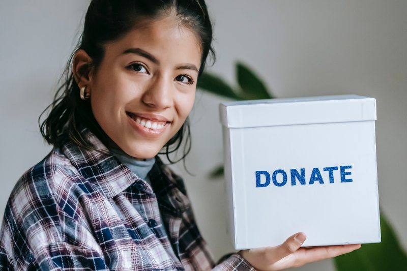 What are In-kind donations - woman holding donations box