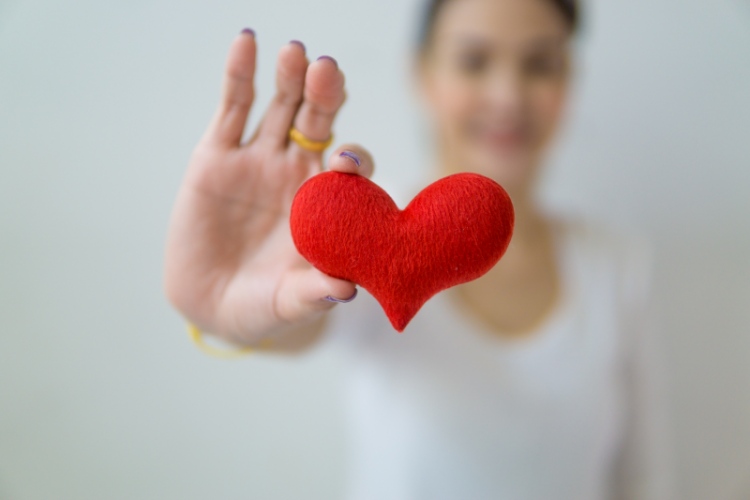 Woman holding heart for charity and nonprofit fundraising